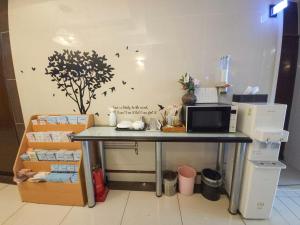 a kitchen with a table with a microwave and some boxes at 글로벌인 동대문 시티데이즈 인 호텔 in Seoul
