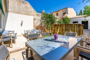 a patio with a glass table and chairs at Sant Antoni 39 in Llucmajor