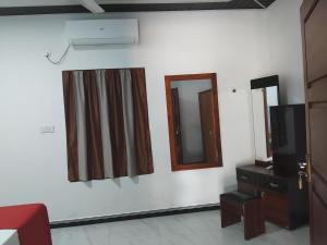 a room with two mirrors and a tv on a wall at Nesan’s villa in Trincomalee