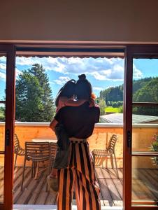 a woman standing on a porch looking out a window at tobel 1853 apartments in Leutkirch im Allgäu