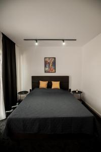 a bedroom with a black bed with two yellow pillows at Incanto Rentals in Silistra