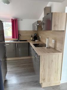 a kitchen with wooden cabinets and a counter top at Ferienwohnung Amselnest in Seeboden +18 photos