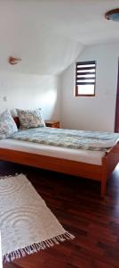a large bed in a room with a window at Casa Marty in Cârțișoara