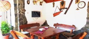 a dining room with a wooden table and chairs at Casa Marty in Cârțișoara
