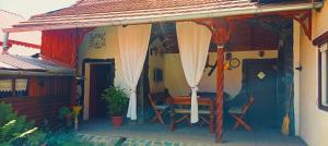 a porch of a house with a table and chairs at Casa Marty in Cârțișoara