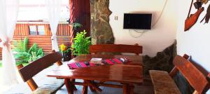 a dining room with a wooden table and a television at Casa Marty in Cârțișoara