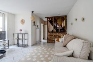 a living room with a couch and a fireplace at La Ferté - Centre-ville - Petfriendly in La Ferté-Bernard