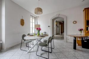 a dining room with a white table and chairs at La Ferté - Centre-ville - Petfriendly in La Ferté-Bernard