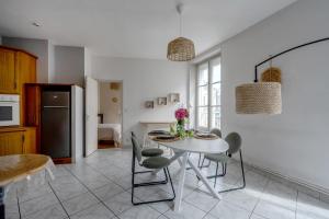 a kitchen and dining room with a table and chairs at La Ferté - Centre-ville - Petfriendly in La Ferté-Bernard +8 photos