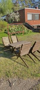 a picnic table and bench sitting in the grass at Hyryntie 33 as 3 in Hyrynsalmi