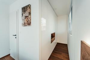 a hallway with a door and a wall with paintings at Modern Seaside House in Pakoštane +11 photos