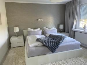 a bedroom with a large white bed with white pillows at Ferienwohnung Edelweiss am Steinberg in Goslar mit Terrasse und Garage in Goslar