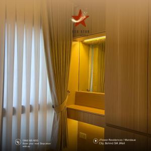 a room with a window with a curtain and a mirror at JTower Residences Mandaue in Mandaue City