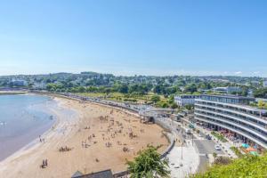 a view of a beach with people on it at Esplanade Court Apartment with communal seasonal heated pool in Paignton