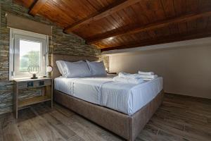 a bedroom with a large bed with a window at En Sophia Guesthouse in Maronia +79 photos
