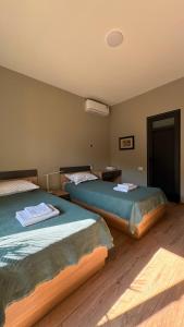 two beds sitting in a room with wooden floors at Ararat Terrace House in Ashtarak