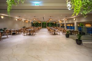 a banquet hall with tables and chairs in a restaurant at Narcissos Waterpark Resort in Protaras