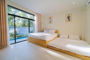 two beds in a room with a large window at Radarin Villa in Ban Khao Kloi +68 photos