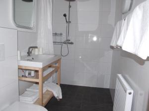 a white bathroom with a sink and a shower at Ferienwohnungen Kindl in Neustift im Stubaital +36 photos
