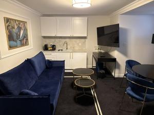 a living room with a blue couch and a kitchen at Willa Ingeborg in Międzyzdroje