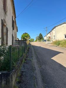an empty street next to a building and a fence at LEMAFIOlY in Cemboing