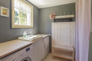 a bathroom with a sink and a washing machine at Gite Cottage de la Douloustre in Montgaillard