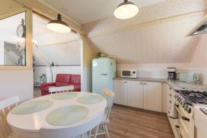 a kitchen with a table and a refrigerator at Gite Cottage de la Douloustre in Montgaillard