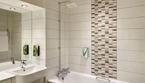 a bathroom with two sinks and a tub and a mirror at Wirral Park Hotel in Greasby +15 photos