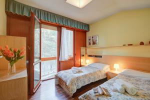a hotel room with two beds and a window at Lo Stambecco - Duplex for 8 people - Happy Rentals in Bardonecchia