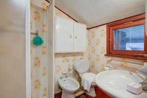 a bathroom with a toilet and a sink and a window at Lo Stambecco - Duplex for 8 people - Happy Rentals in Bardonecchia +27 photos