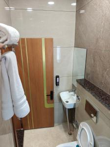 a bathroom with a toilet and a sink at Hotel ROYAL DC in Alīgarh