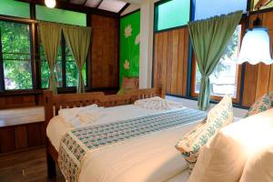 a bedroom with two beds in a room with windows at Khom Chiang Mai in Chiang Mai +76 photos