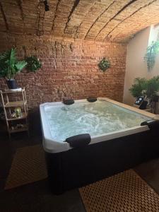 a hot tub in a room with a brick wall at Osada Narost 37 in Chojna
