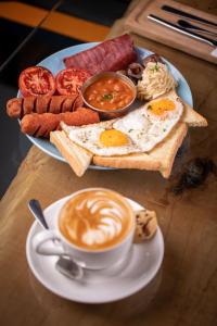 a plate of breakfast food with a cup of coffee at Tarlan Hotel in Aktau