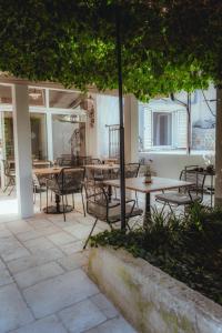 a patio with tables and chairs under a tree at Casa Segota in Veli Iž