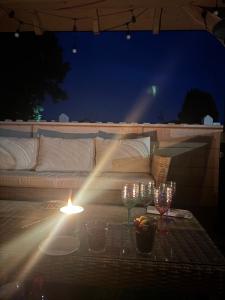 a table with wine glasses and a candle on a patio at Osada Narost 37 in Chojna