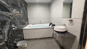 a bathroom with a sink and a bath tub at Mojo stay hotel in Ahmedabad +19 photos