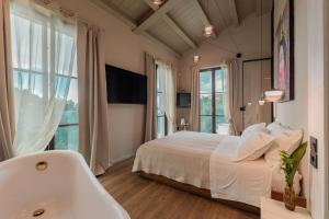 a bedroom with a white bed and a bath tub at Tenuta Zamparina in Montignoso