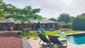 a yard with chairs and a pool and a house at Gîte L'Orée des Bois in Paimpont