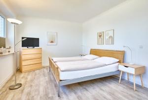 a bedroom with two beds and a tv at Haus Schildt, FeWo 8 in Duhnen
