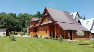 a large wooden house with a large yard at Chałupka na szlaku Zacisze in Biały Dunajec