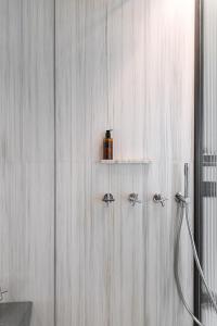 a white bathroom with a shower with a hose at Tenuta Zamparina in Montignoso