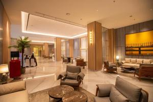 a lobby with couches chairs and tables in a building at Pristine Living at Tokyo Riverside PIK2 in Muara