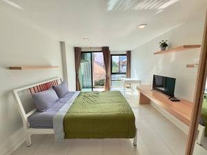 a bedroom with a bed and a television in it at Peaberry Place - พีเบอร์รี่เพลส in Ban Zong Katiam