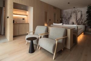 a bedroom with two chairs and a bed and a table at Zen Emerald Resort & Spa, Soča river in Most na Soči +32 photos