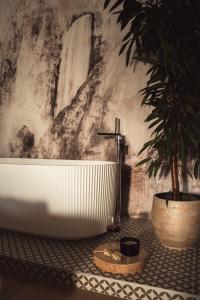 a bathroom with a bath tub and a potted plant at Zen Emerald Resort & Spa, Soča river in Most na Soči