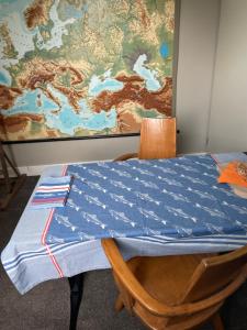 a table with a blue table cloth on it with a map at Homestay Bij de Heldinnen in Helden