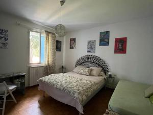 a bedroom with a bed and a window at Notre campagne provençale in Avignon