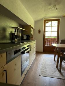 a kitchen with a counter and a table and a window at Guggenbergerhof in Maria Luggau