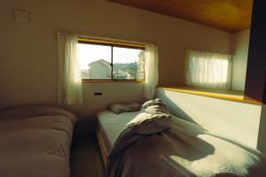 a small bedroom with two beds and a window at 浬-kairi-1852 in Choshi